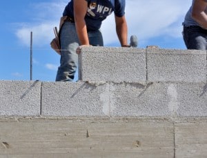 Artisan réalisant un mur en parpaing