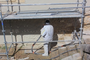 Artisan façadier nettoyant une façade en pierre