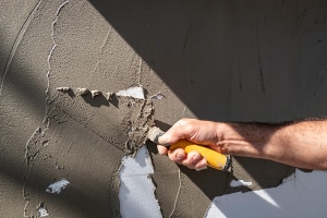 Travaux d'enduit sur mur de clôture